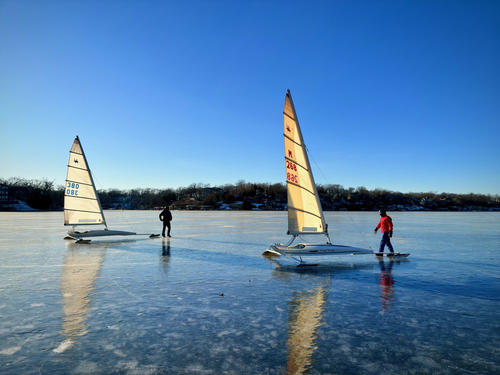 Two iceboats with sails up on the frozen surface of Lake Lotawana