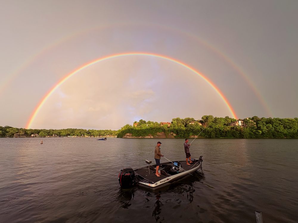 A double rainbow over Lake Lotawana while two anglers fish from a boat