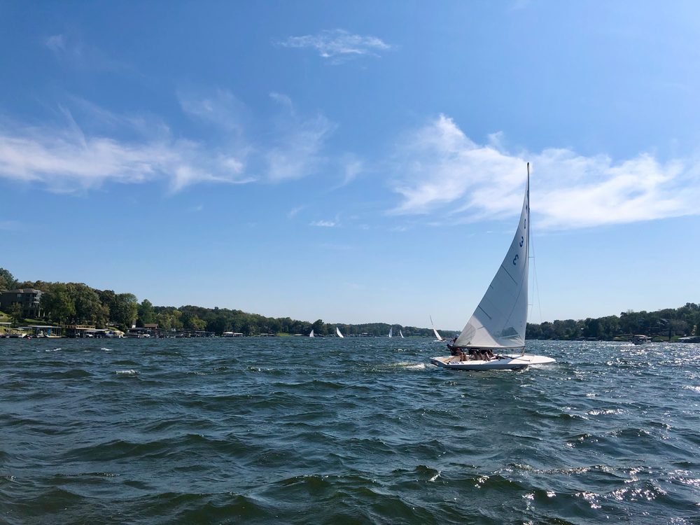 A sailboat racing on Lake Lotawana on a clear afternoon