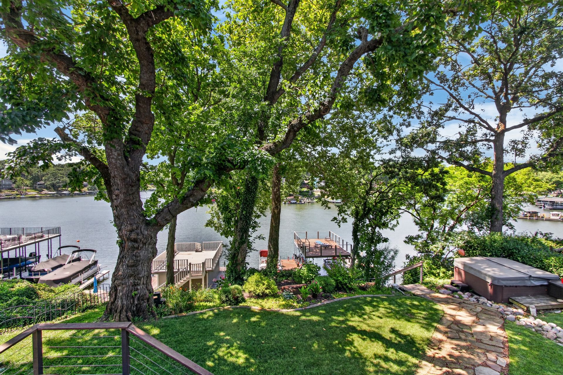 Backyard lawn leading down to the dock and hot tub at 31 H Street, Lake Lotawana