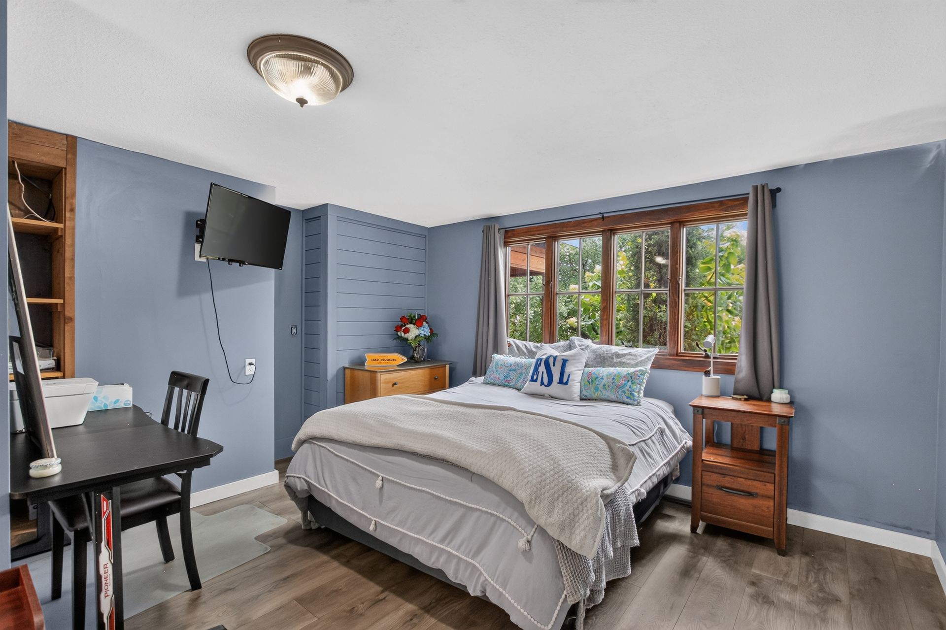 Guest bedroom with blue walls and mounted TV at 31 H Street, Lake Lotawana