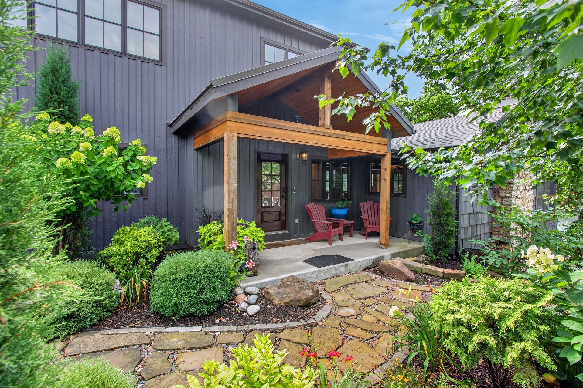 Covered front porch entry with red Adirondack chairs at 31 H Street, Lake Lotawana