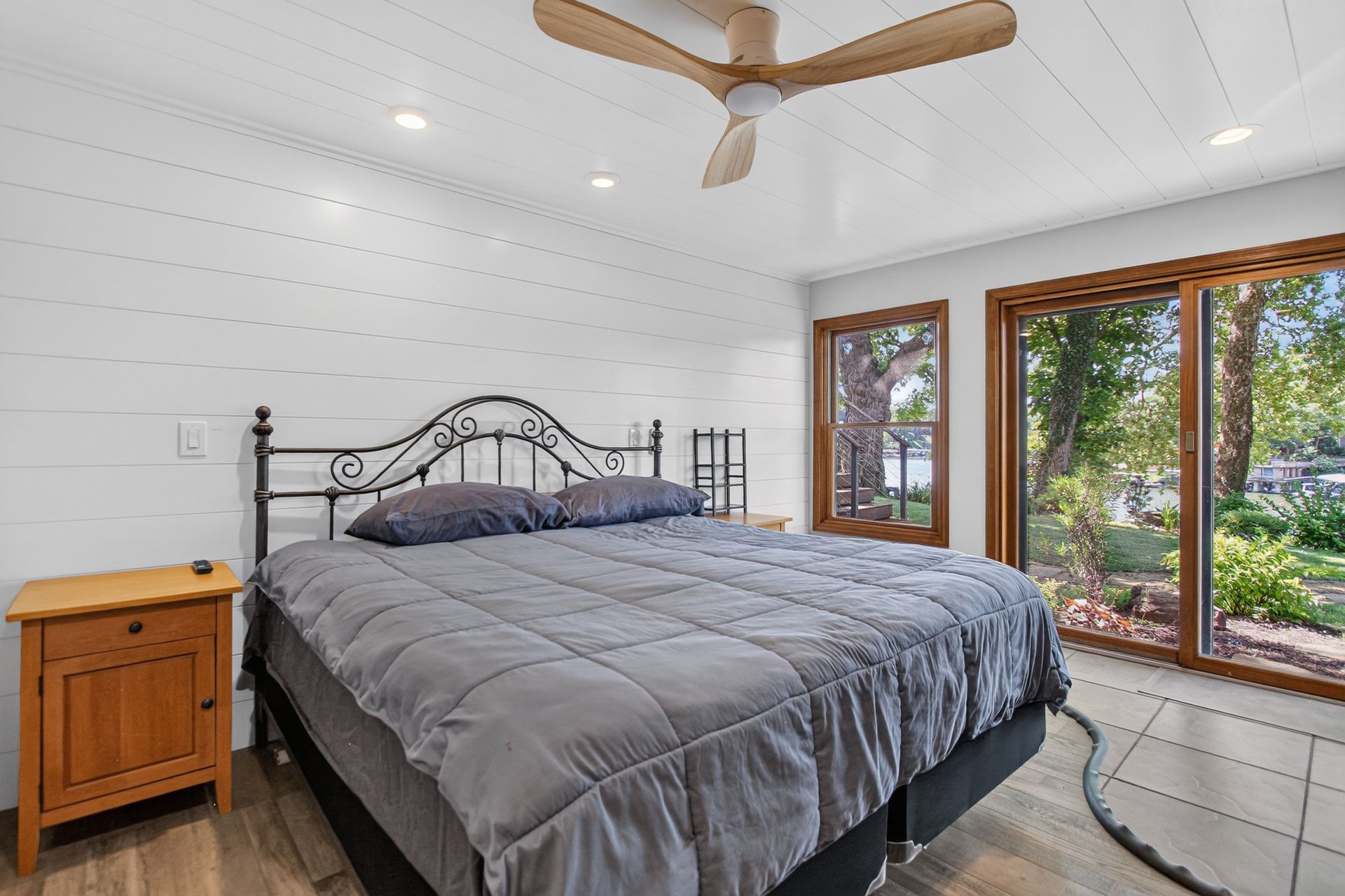 Main-level bedroom suite with white shiplap walls and walkout access at 31 H Street, Lake Lotawana