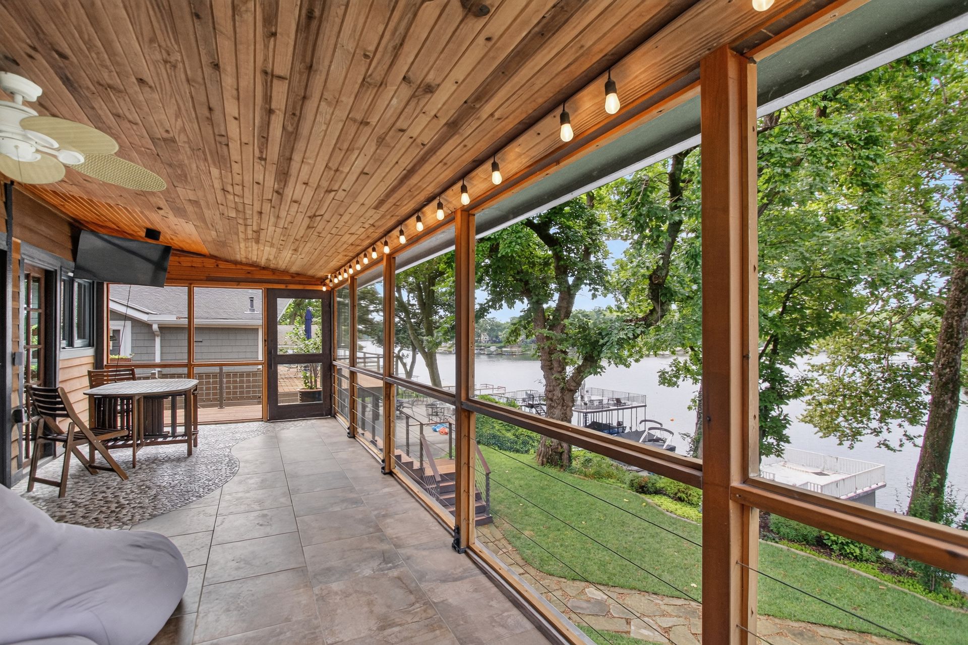 Screened porch dining area overlooking Lake Lotawana at 31 H Street