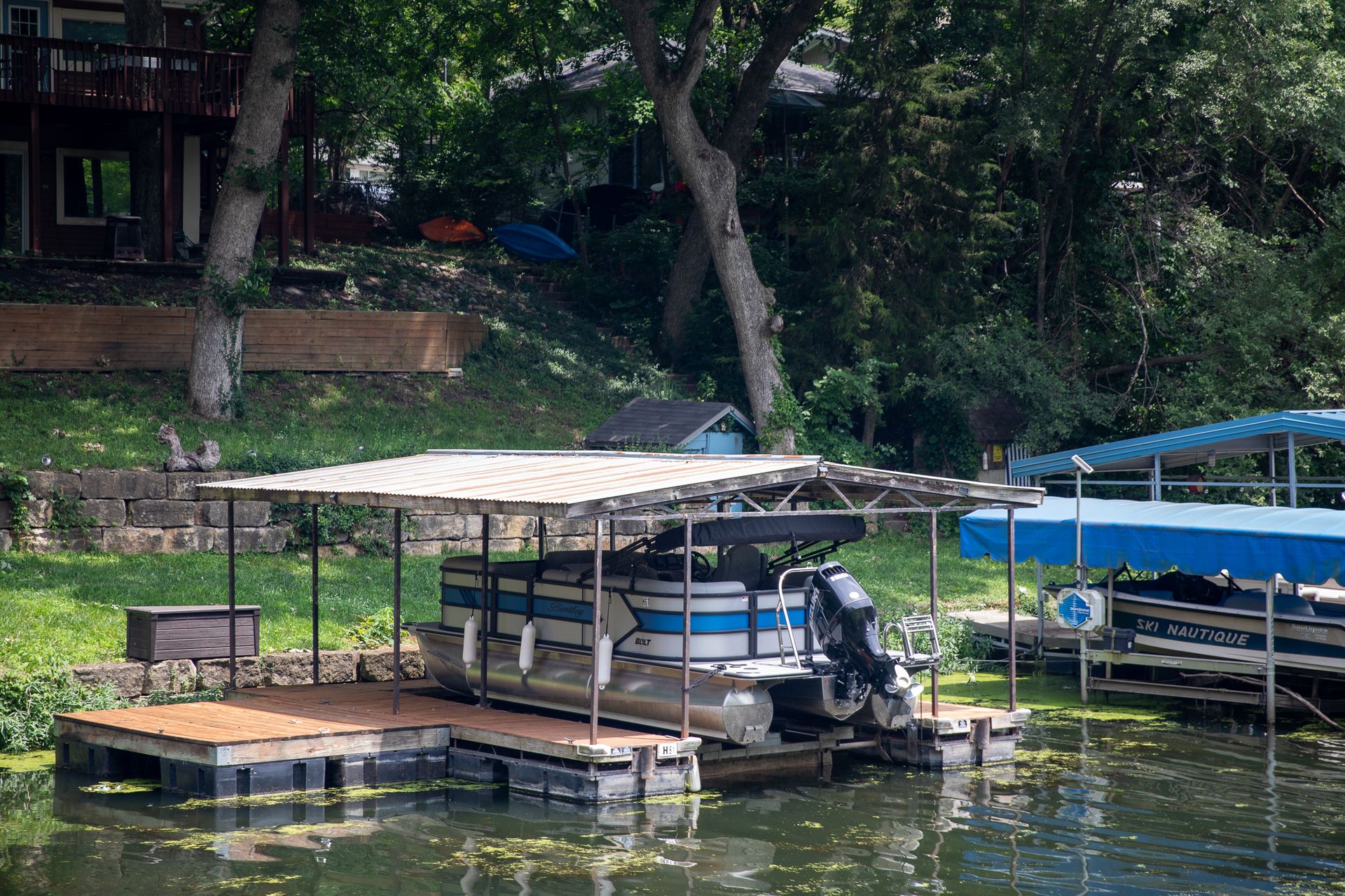 Covered dock with pontoon boat lift viewed from the water at 61 H Street, Lake Lotawana