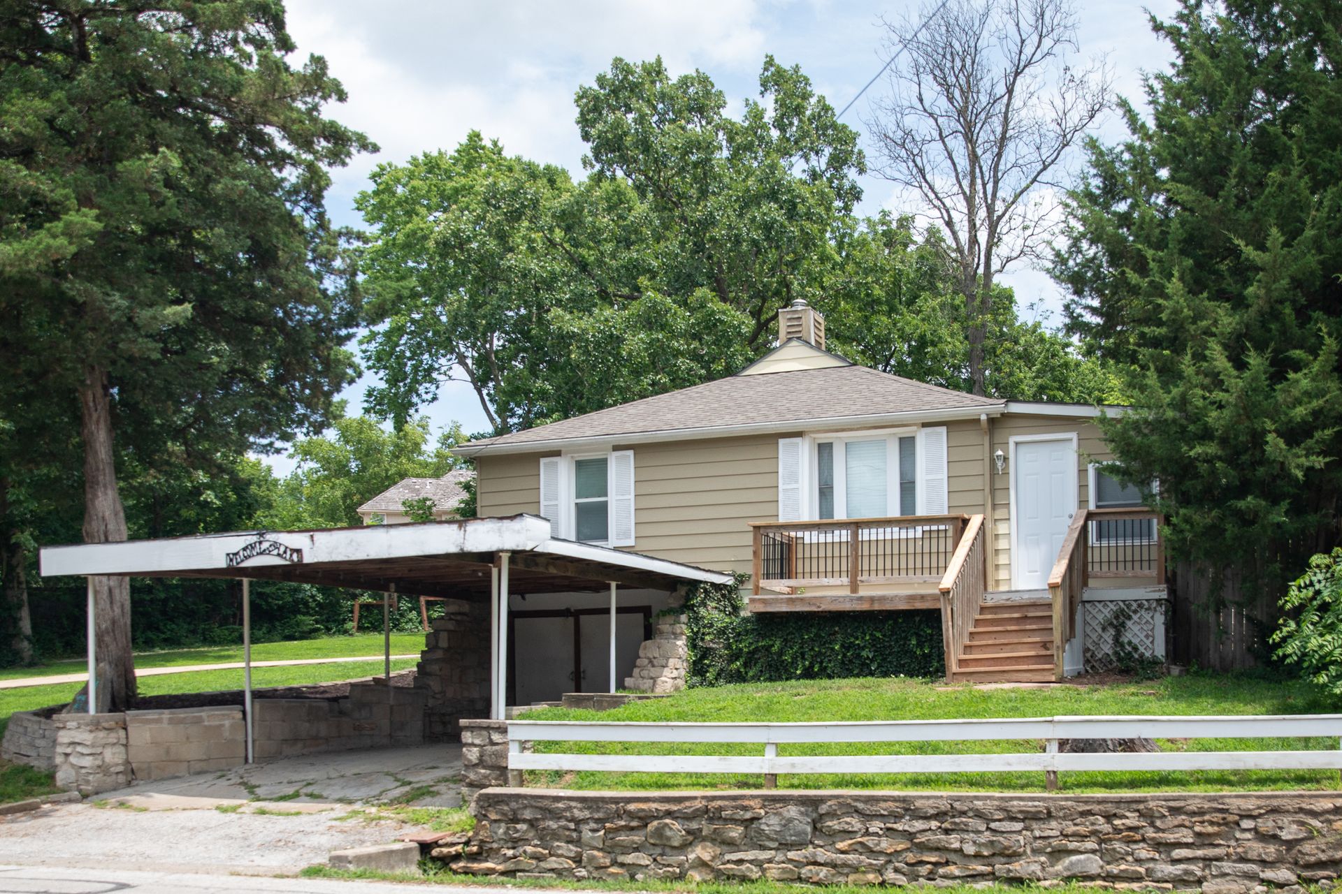 Front exterior of 61 H Street showing the carport, deck, and entry stairs, Lake Lotawana