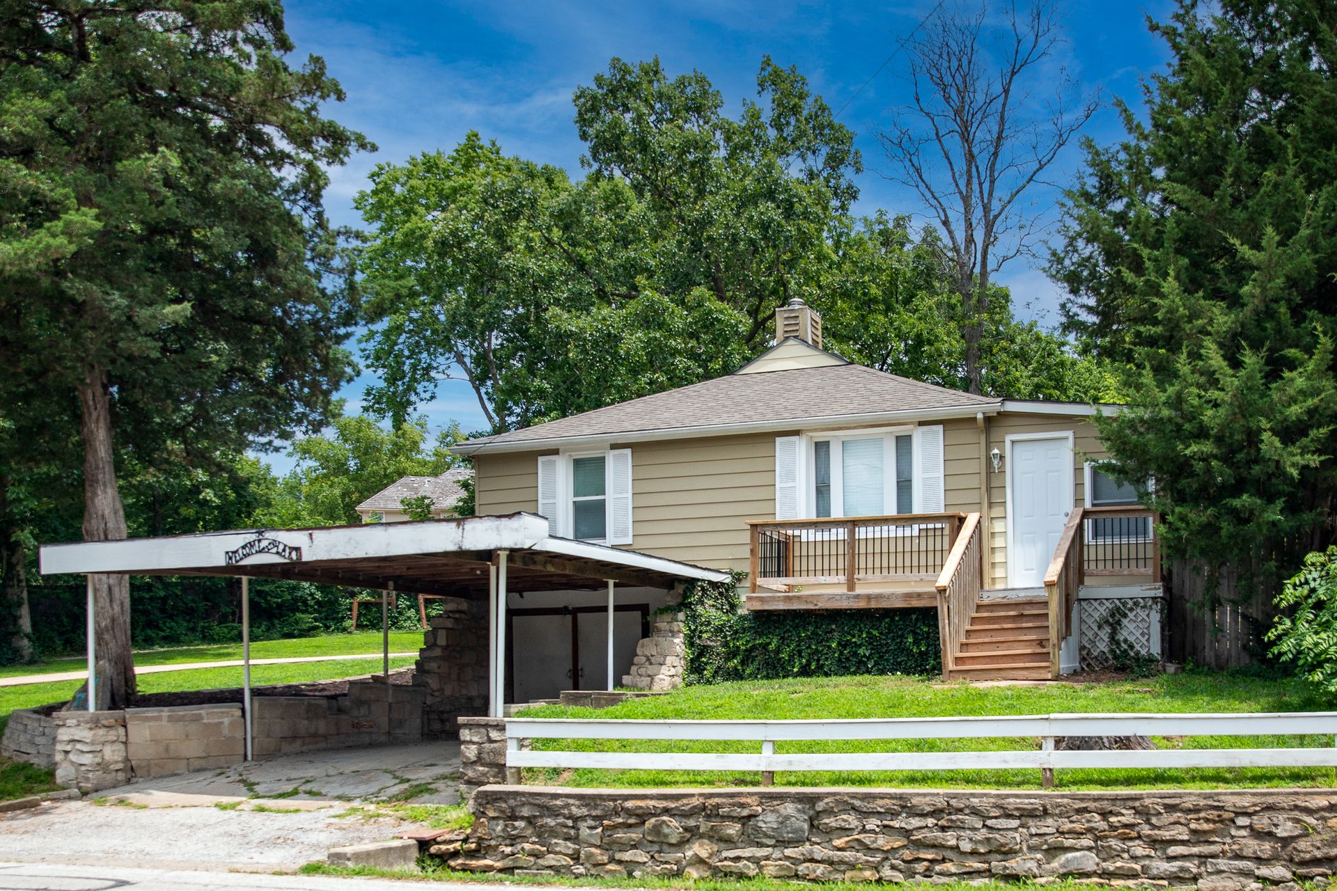 Daytime front exterior of 61 H Street with carport and deck, Lake Lotawana