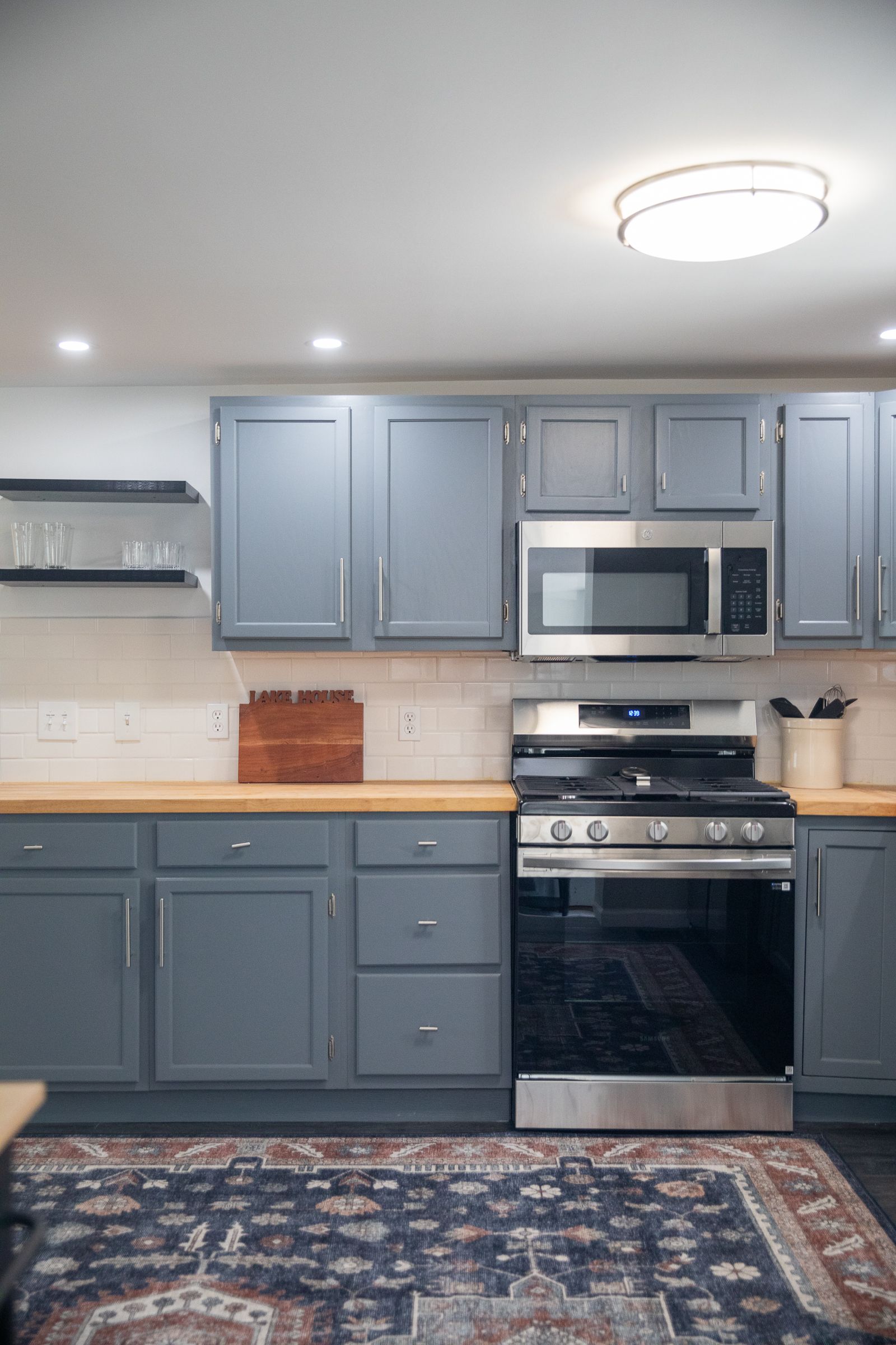 Kitchen range and microwave with blue-gray cabinetry at 61 H Street, Lake Lotawana