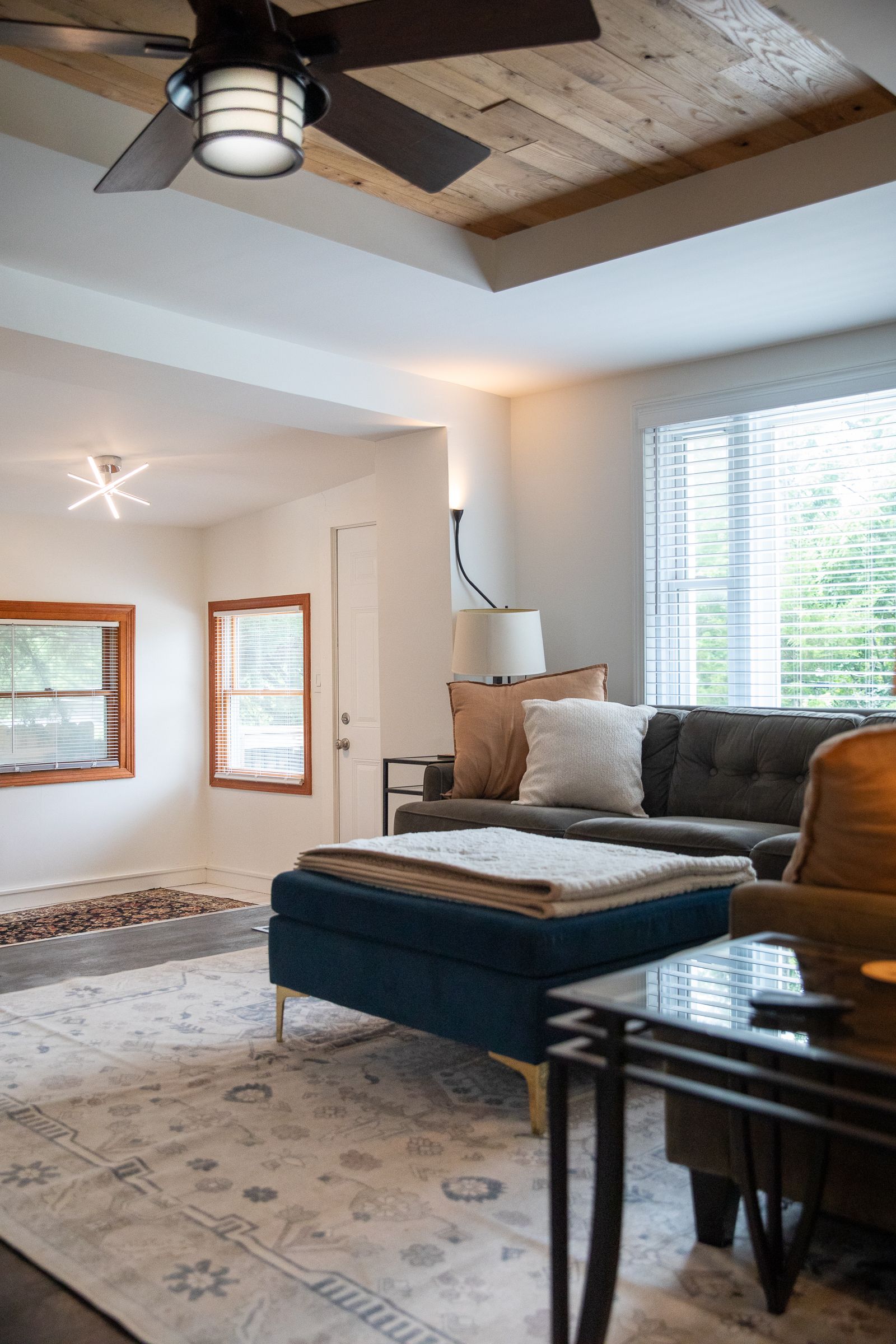 Living room with wood tray ceiling and gray sofa at 61 H Street, Lake Lotawana